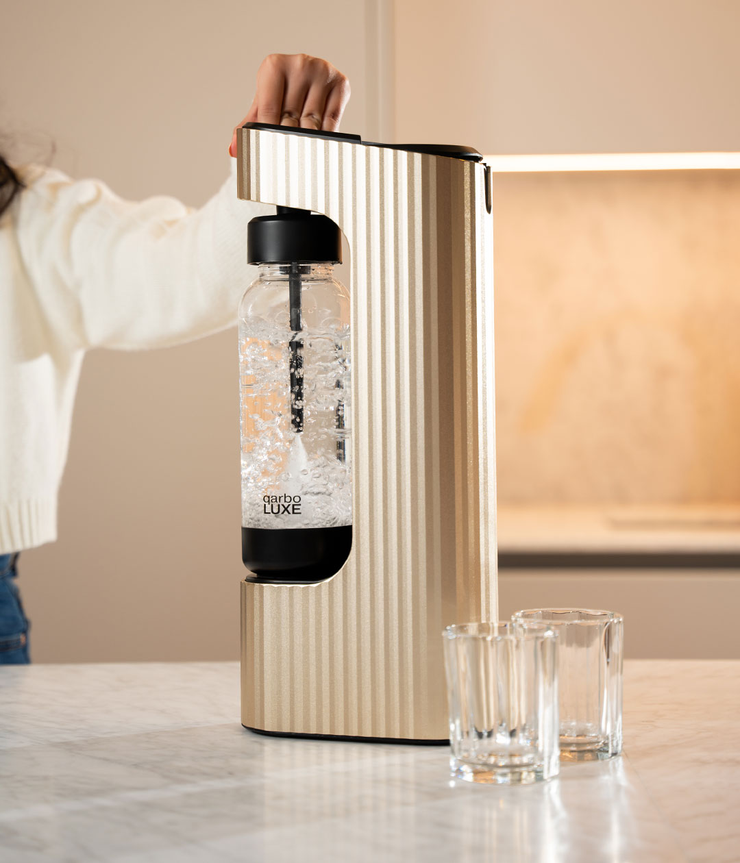 Qarbo gold soda maker pouring sparkling drink
