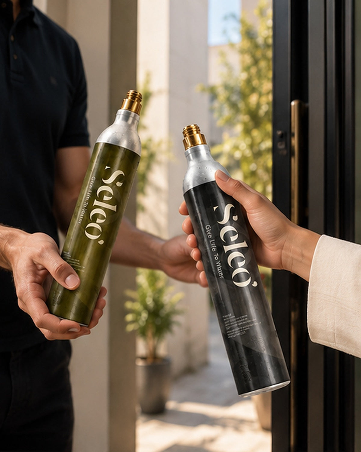 Delivery driver handing over a full Seleo CO2 cylinder while the customer hands back the empty one at the door
